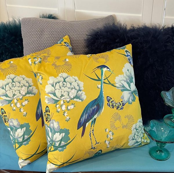 Egret cushions on teal with glassware